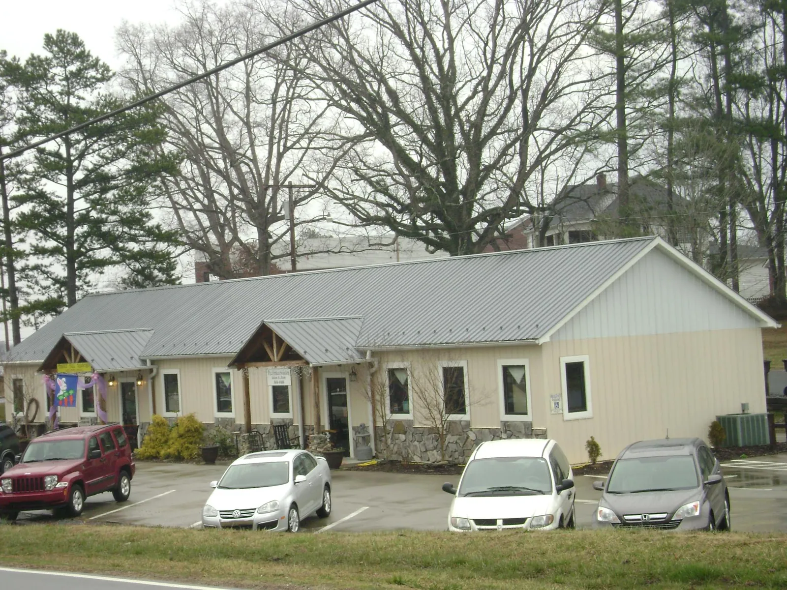 Gray metal roof with timber entry brackets on a small commercial building in Hankins